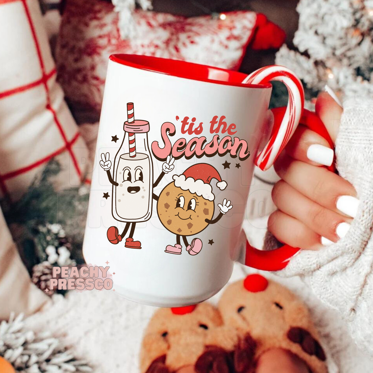 Christmas coffee mug with red handle featuring retro cartoon milk bottle and chocolate chip cookie holding hands with text Tis The Season.