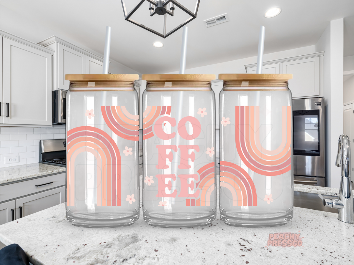 Glass cup tumbler featuring retro pink rainbows, flowers, and the word "Coffee" in a soft pastel aesthetic design.