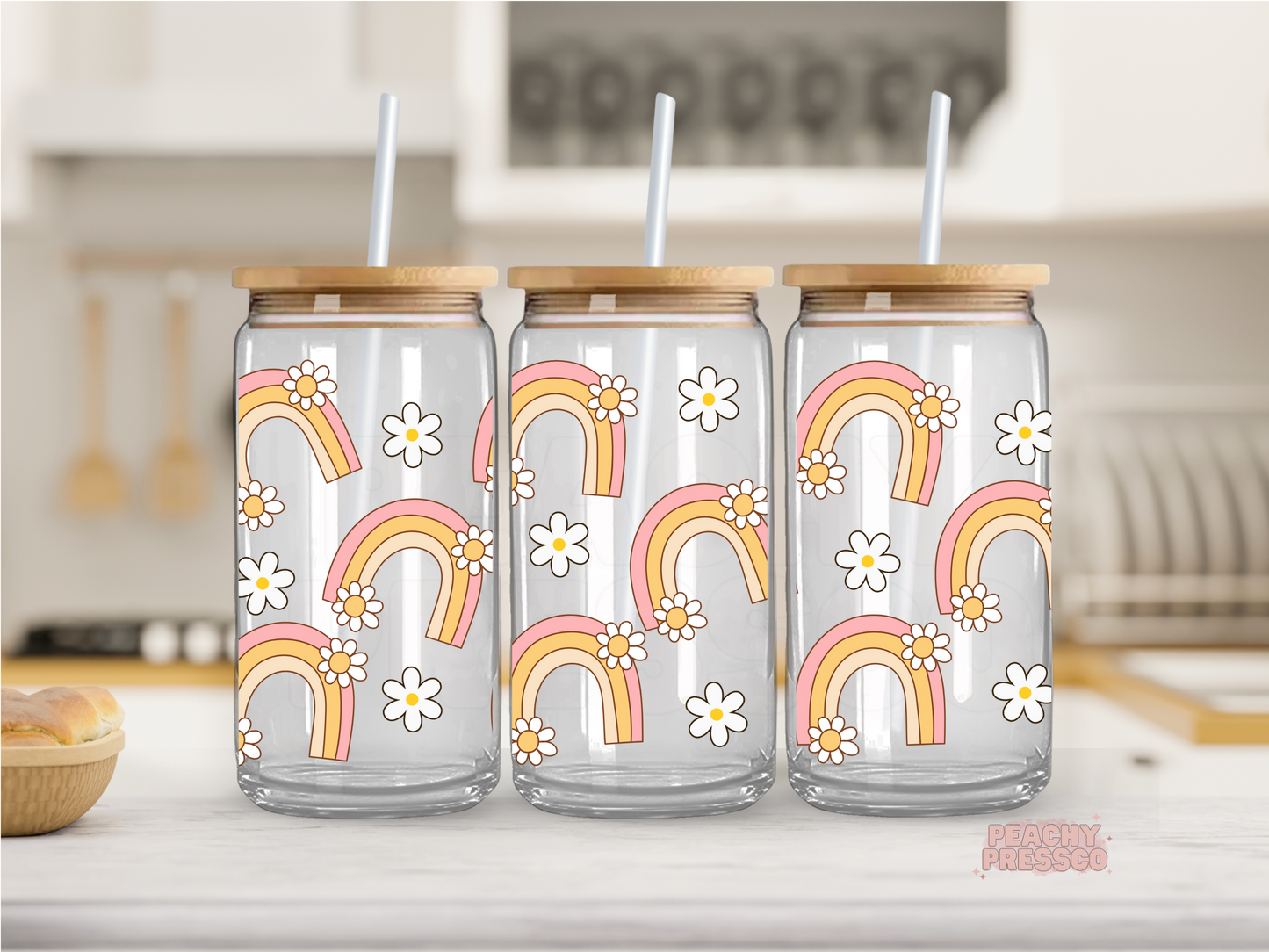 16 oz clear glass cup featuring retro rainbows and white daisy flowers in pink and mustard tones. Includes bamboo lid and reusable straw.
