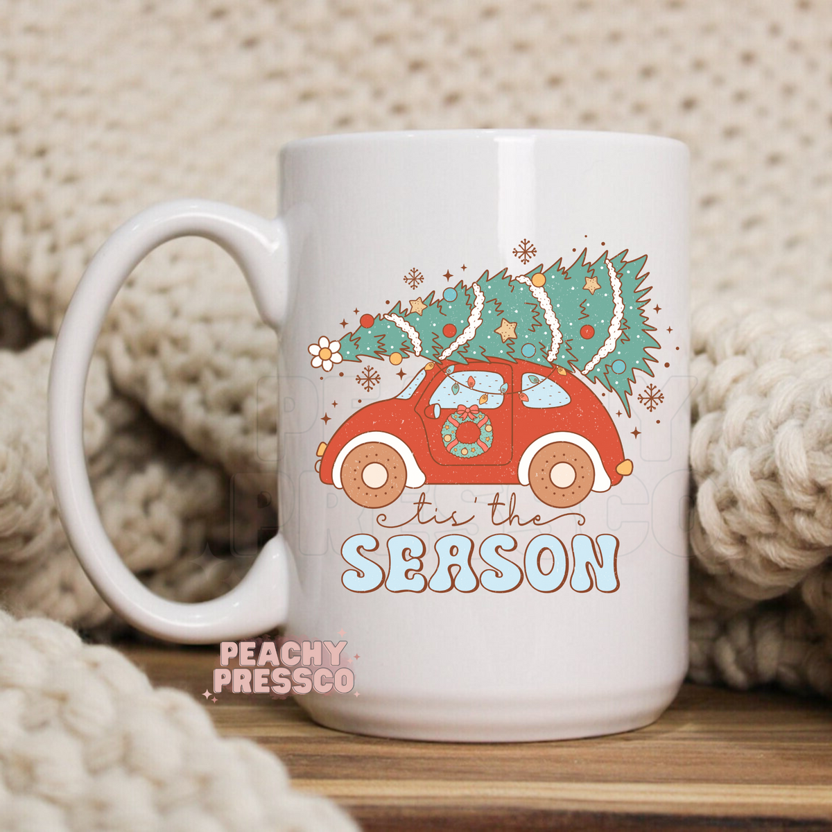 White ceramic mug with retro red car carrying a Christmas tree on top and groovy text reading tis the Season.