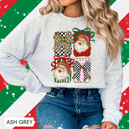 A woman wearing an ash grey crewneck sweatshirt with a festive graphic print of four Christmas gift boxes featuring Santa, leopard print, and checkered patterns, set against a holiday-themed diagonal striped background.