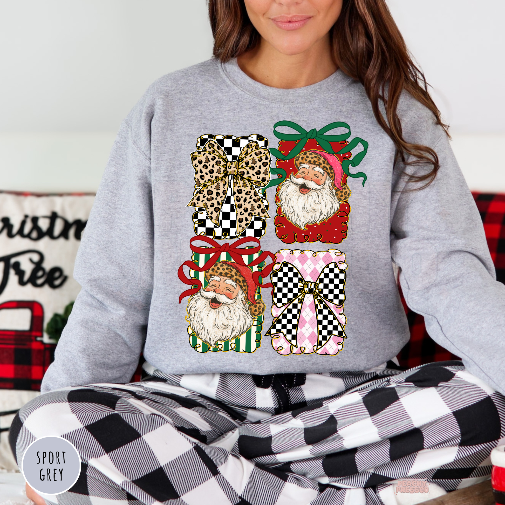 Women sitting in black and white buffalo plaid pajama pants wearing a sport grey holiday sweatshirt with checkered bows and retro Santas.