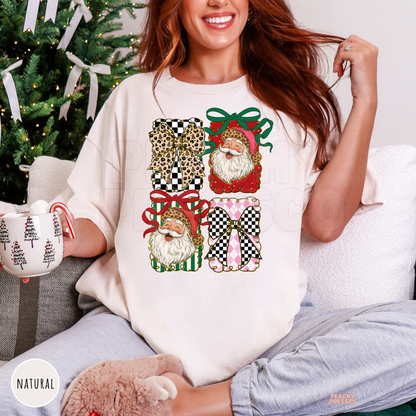 Women relaxing on a couch wearing a natural cream oversized holiday t-shirt featuring leopard bows and retro Santa graphics while holding a mug.