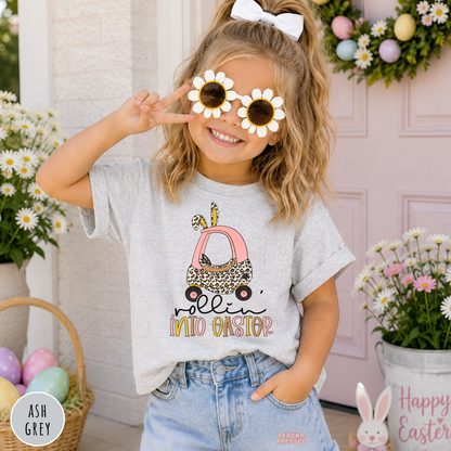 Toddler girl wearing an ash grey Rollin Into Easter shirt with a cute pink bunny car and leopard print Easter graphic.