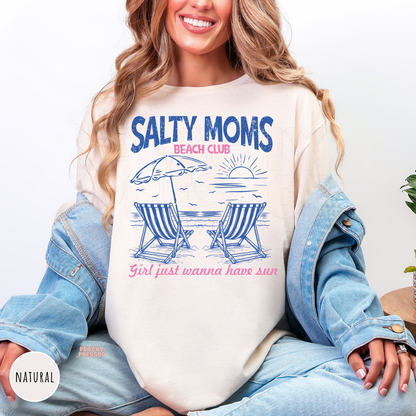 Natural Comfort Colors t-shirt featuring a retro "Salty Moms Beach Club" beach graphic with striped chairs, ocean sunset, and pink accents, perfect for beach vacations and summer.