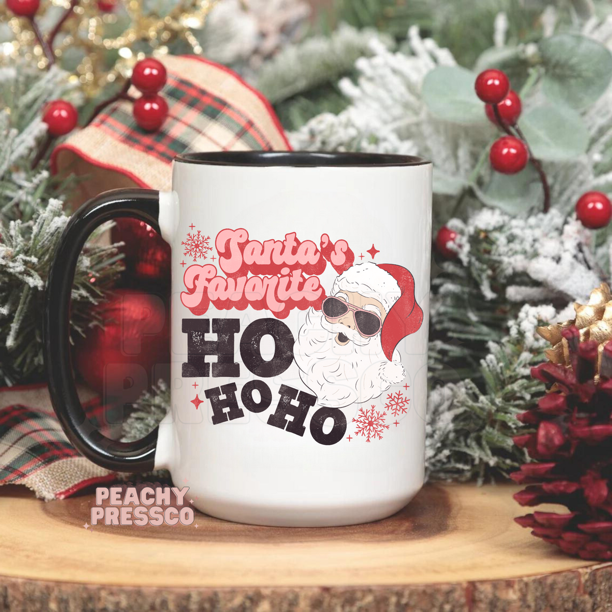 White mug with black handle featuring Santa Claus in sunglasses with pink text reading Santas Favorite HO HO HO.