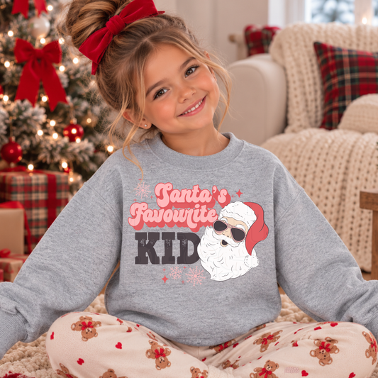 Girl wearing a sport grey Santa’s Favourite Kid Christmas crewneck with a festive Santa graphic.