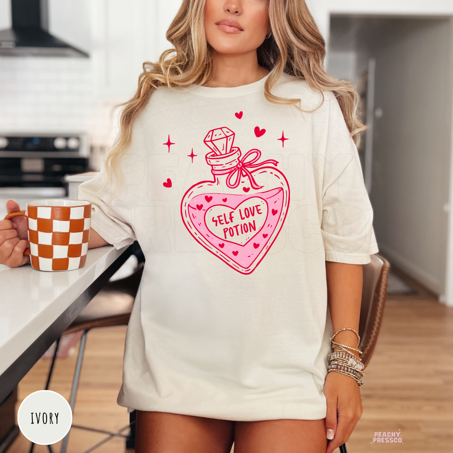 Ivory unisex t-shirt featuring a charming Self Love Potion heart bottle illustration with pink hearts for a cute Valentine's aesthetic.