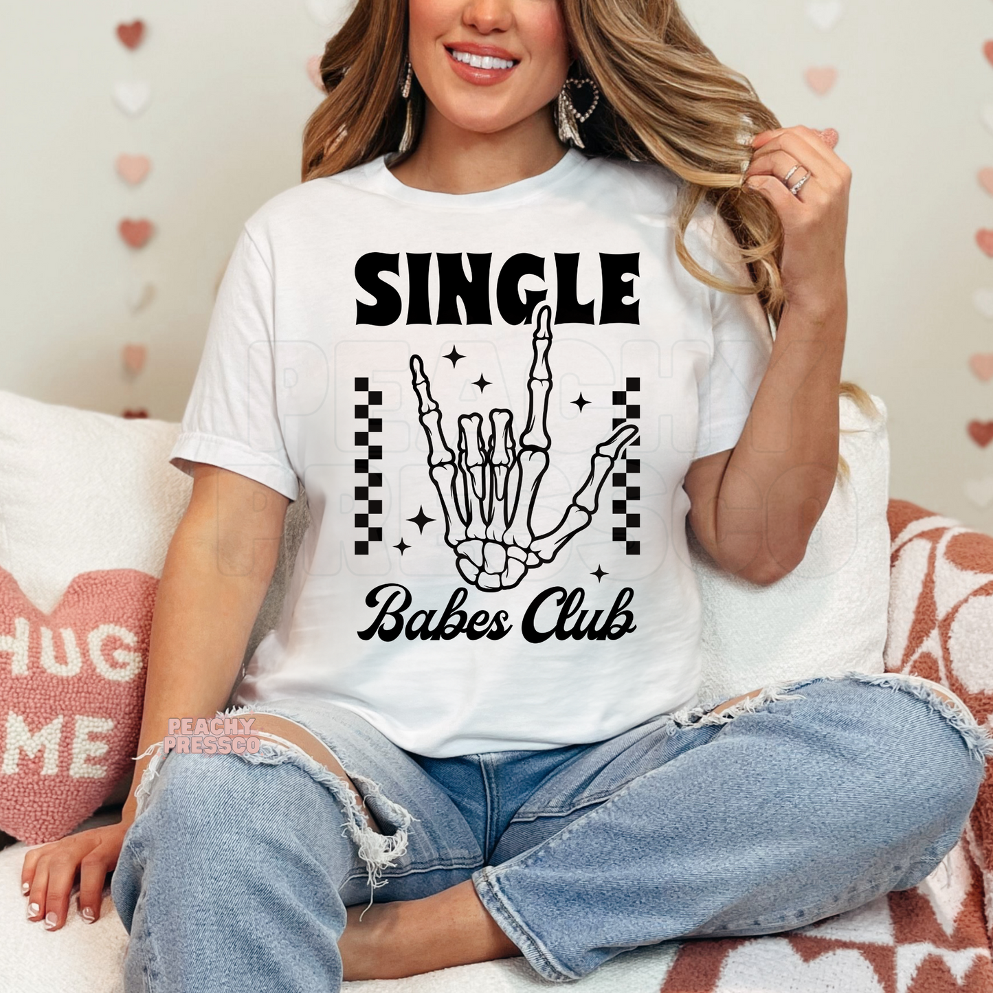White unisex t-shirt featuring a trendy "Single Babes Club" skeleton hand graphic with retro fonts and playful Valentine's aesthetic.
