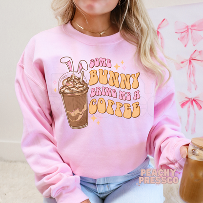 Pink crewneck sweatshirt with a Some Bunny Bring Me A Coffee Easter design featuring a bunny ear iced coffee and retro lettering.