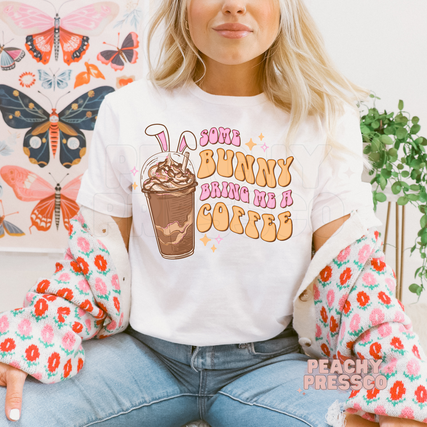 White t-shirt featuring a retro Some Bunny Bring Me A Coffee Easter graphic with bunny ears, iced coffee, and pastel lettering.