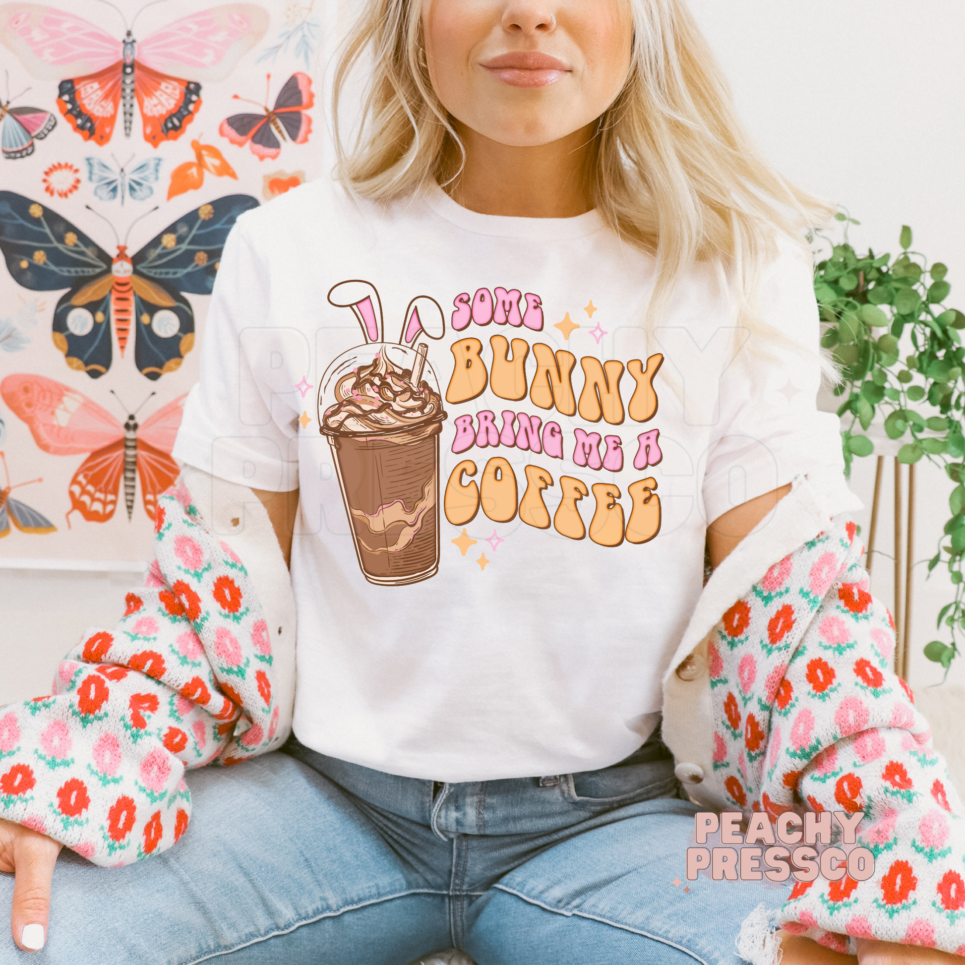 White t-shirt featuring a retro Some Bunny Bring Me A Coffee Easter graphic with bunny ears, iced coffee, and pastel lettering.