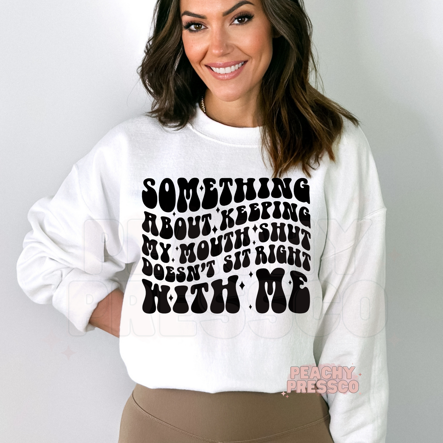 Woman wearing a white graphic sweatshirt featuring the funny sarcastic quote "Something About Keeping My Mouth Shut Doesn't Sit Right With Me" in bold retro lettering.