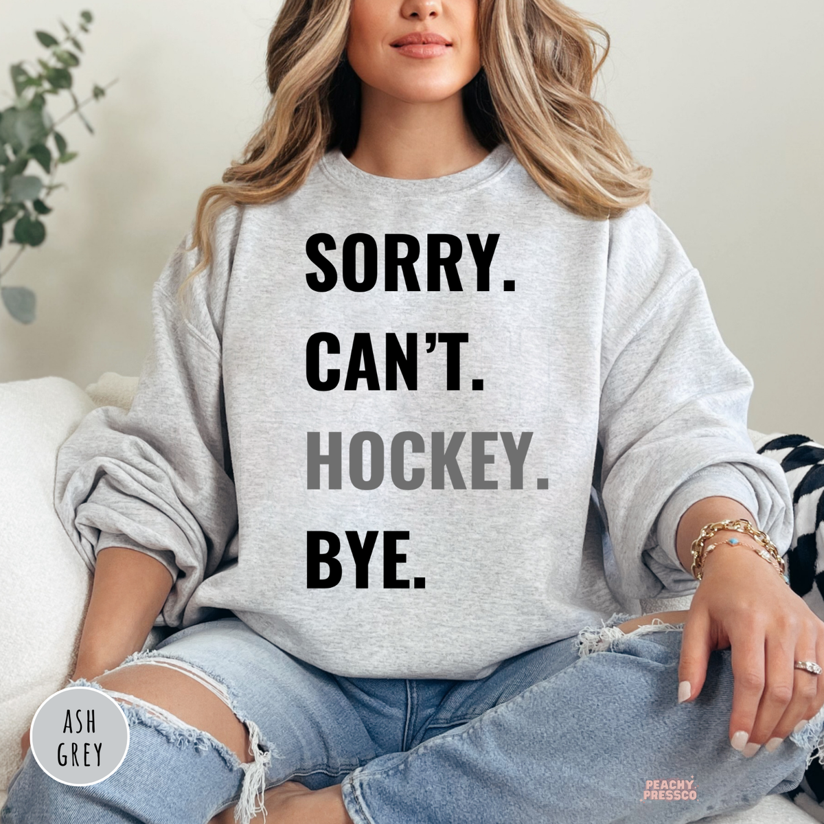 Ash grey crewneck sweatshirt featuring the "Sorry. Can't. Hockey. Bye." graphic in a minimalist style.