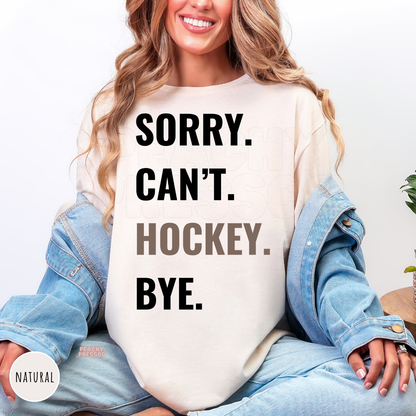 Natural shirt with "Sorry. Can't. Hockey. Bye." graphic for hockey lovers and sports fans.