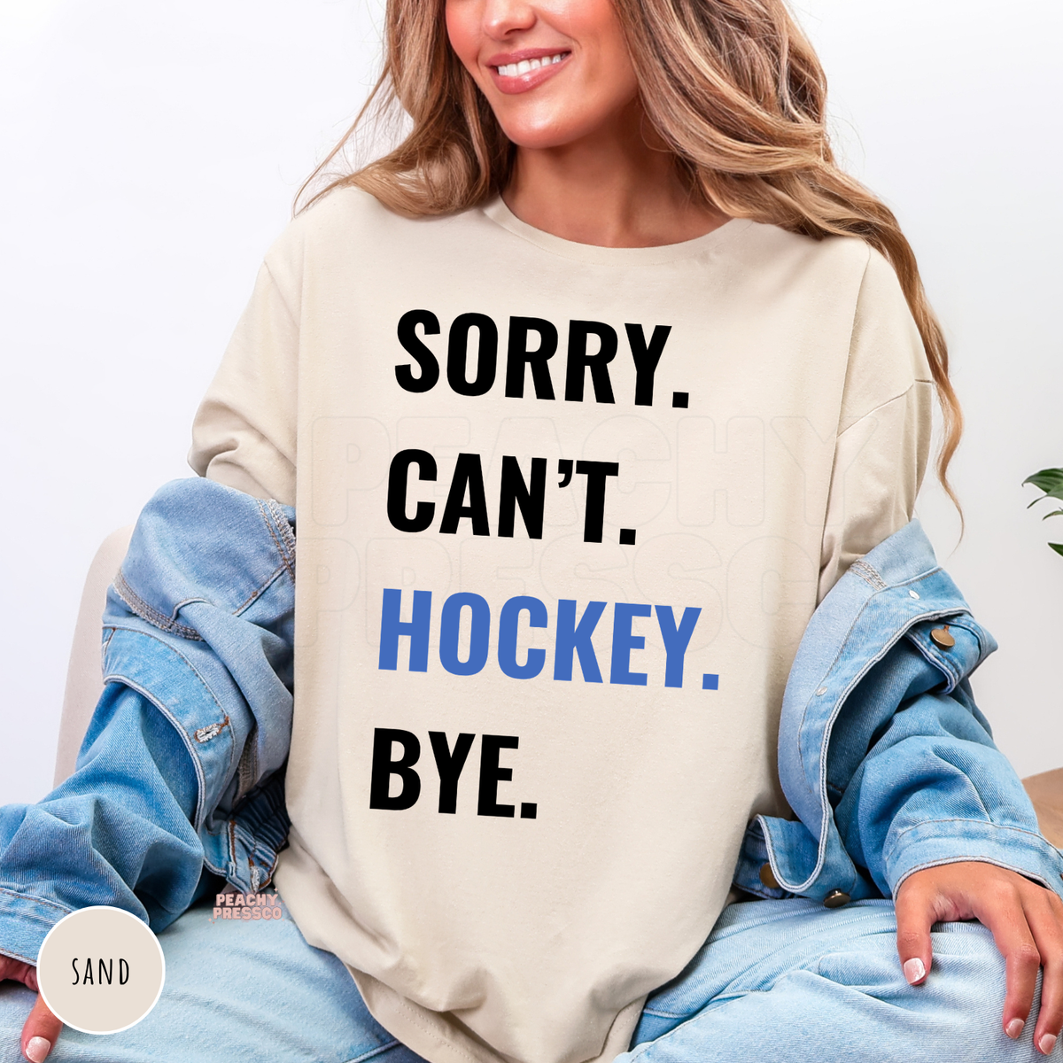 Sand-colored crewneck sweatshirt featuring the "Sorry. Can't. Hockey. Bye." hockey graphic design.