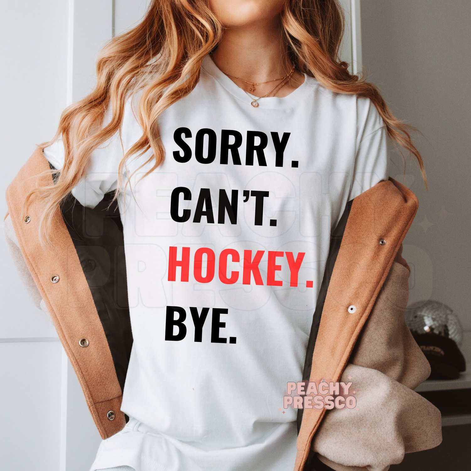 White unisex t-shirt featuring the "Sorry. Can't. Hockey. Bye." graphic with bold red hockey lettering.
