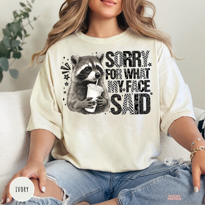 Funny "Sorry For What My Face Said" Comfort Colors t-shirt in Ivory with a vintage raccoon graphic and sarcastic saying, relaxed unisex fit.
