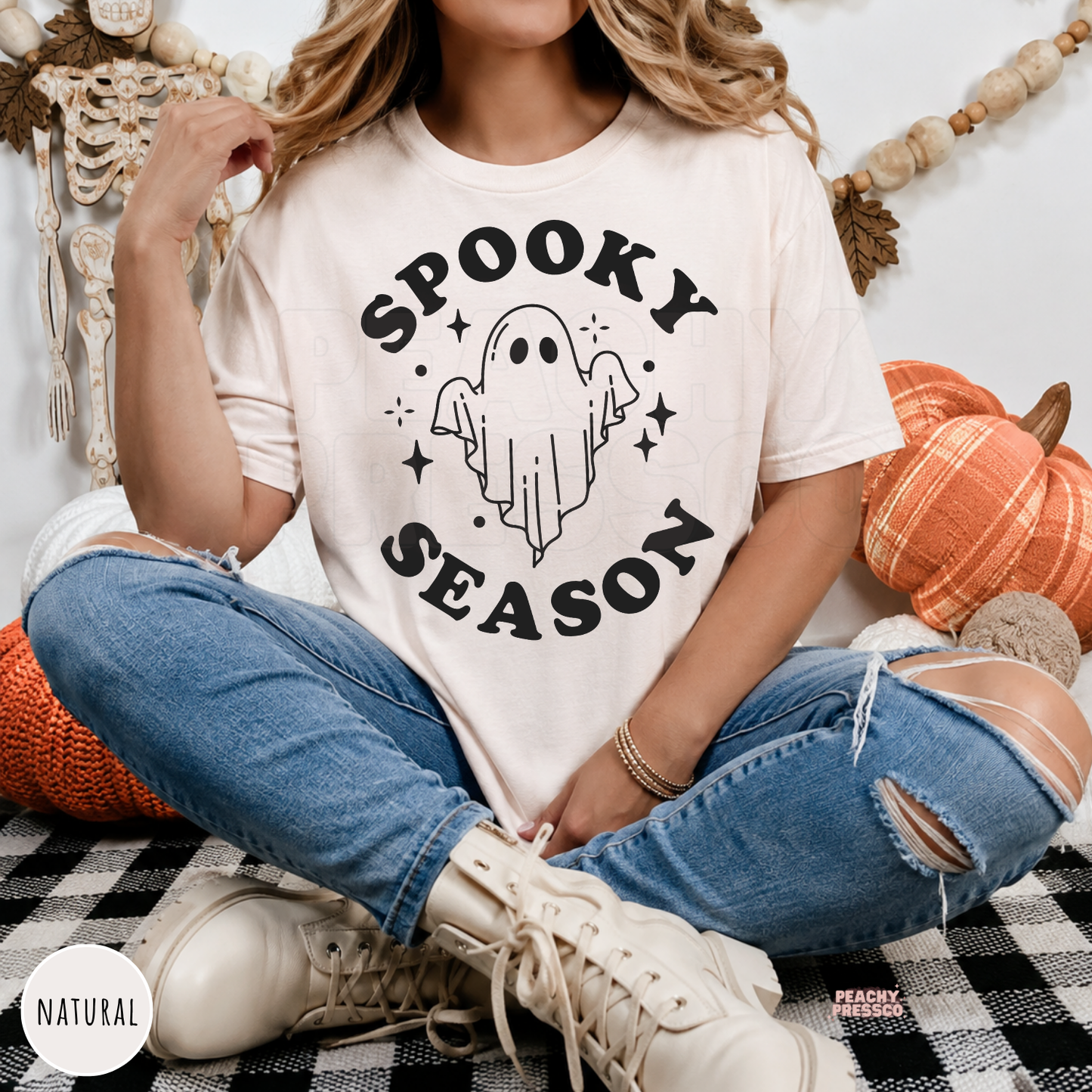 Woman wearing a natural colored Spooky Season ghost Halloween shirt with a minimalist ghost illustration.