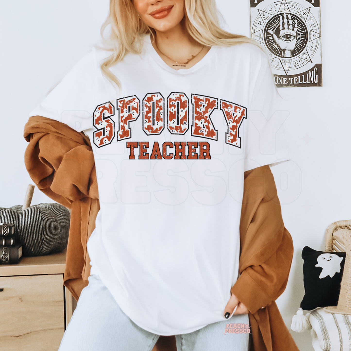 Woman wearing a white Spooky Teacher Halloween graphic t-shirt with distressed varsity ghost print for teachers.