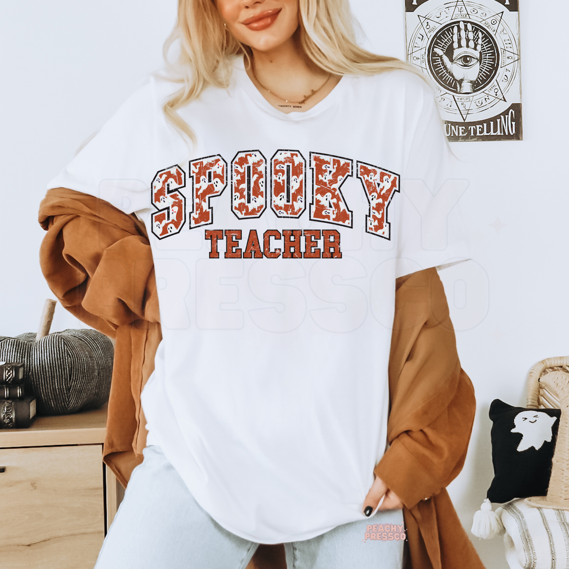Woman wearing a white Spooky Teacher Halloween graphic t-shirt with distressed varsity ghost print for teachers.