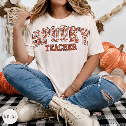 Woman wearing a natural Spooky Teacher Halloween shirt with vintage varsity ghost lettering for spooky season.