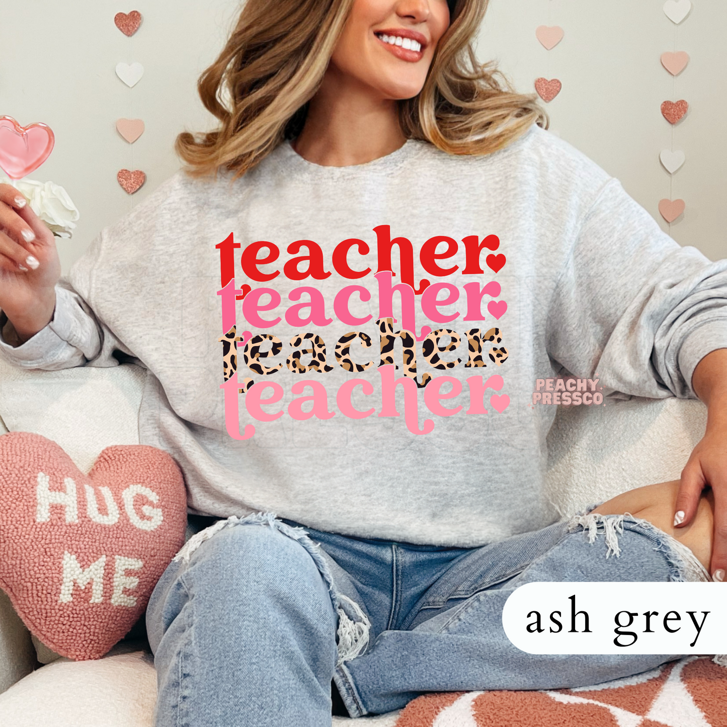 Ash grey crewneck sweatshirt with a stacked Valentine teacher graphic showcasing layered pink typography and leopard print details.