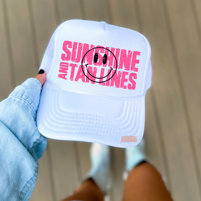 White foam trucker hat featuring a bright pink "Sunshine and Tan Lines" graphic with a black smiley face. Trendy summer trucker cap perfect for beach days, vacations, lake trips, and sunny adventures.