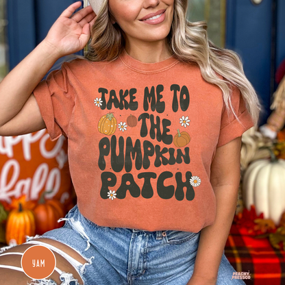 Woman wearing a Comfort Colors yam graphic t-shirt with a retro "Take Me to the Pumpkin Patch" fall design featuring pumpkins and daisies.