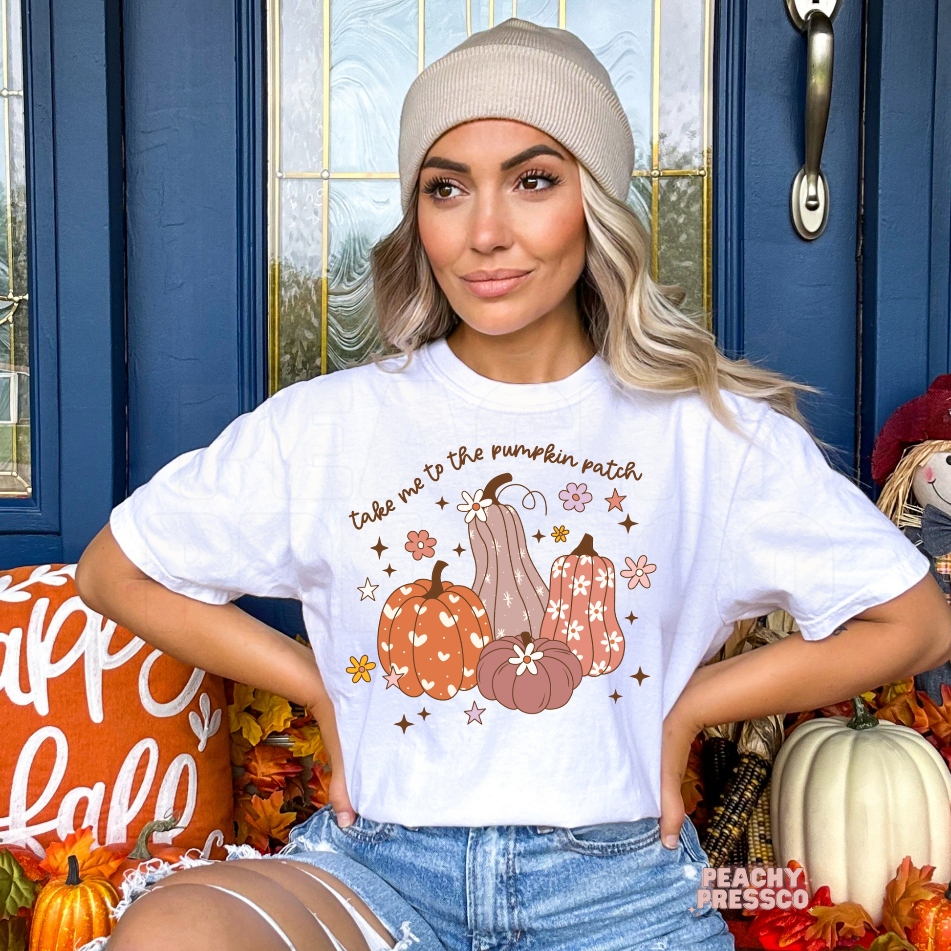 Woman wearing a white graphic t-shirt featuring a "Take Me To The Pumpkin Patch" design with decorative pumpkins, flowers, and autumn details, perfect for fall outings, Thanksgiving, and pumpkin patch photos.