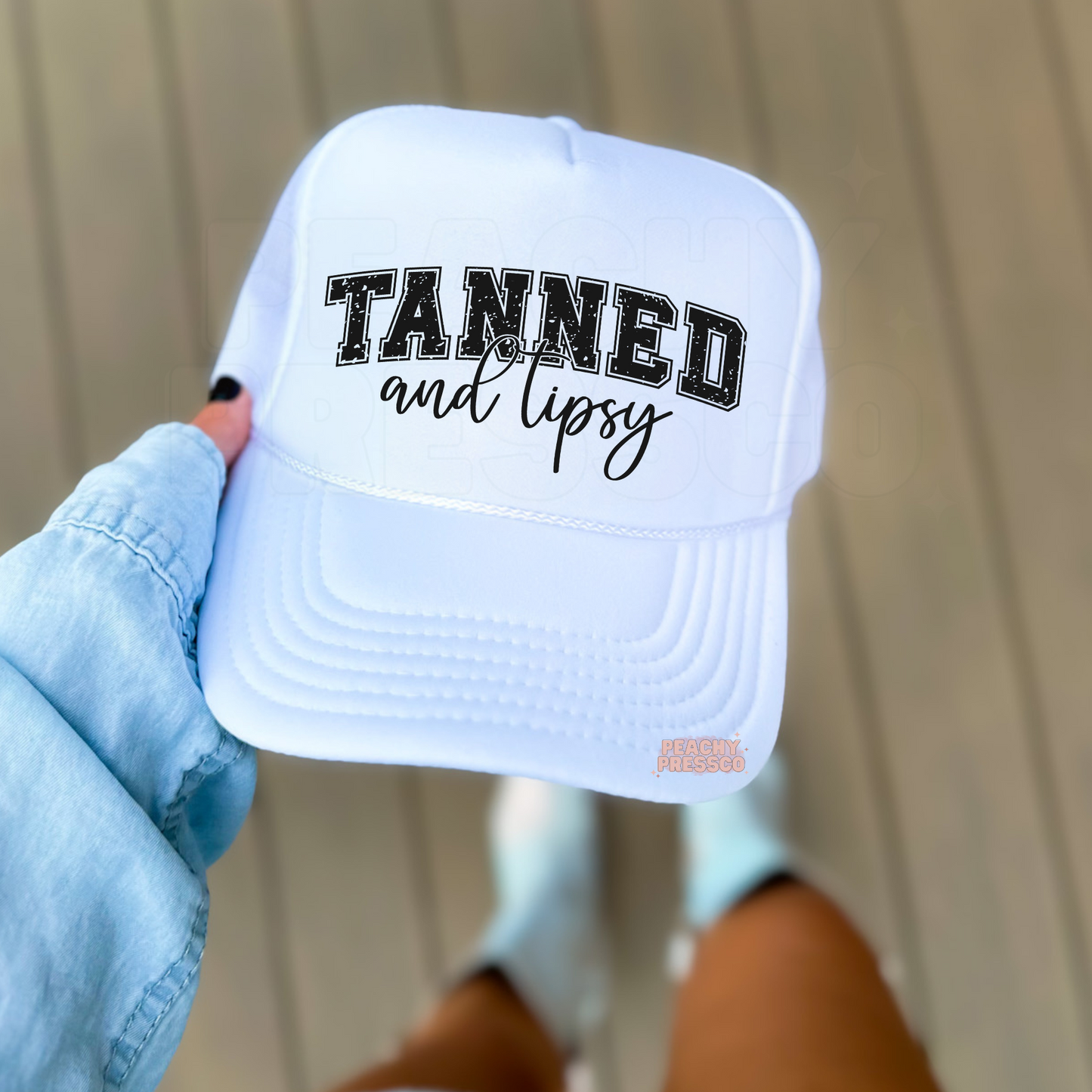 White foam trucker hat featuring the phrase "Tanned and Tipsy" in distressed varsity lettering with stylish script. Cute summer hat for beach lovers, lake days, vacations, boating, poolside cocktails, and weekend adventures.