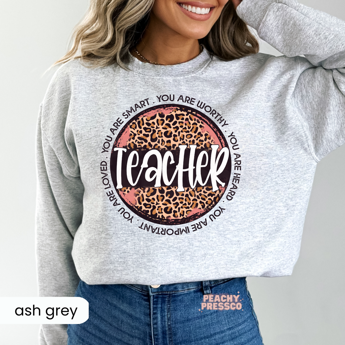 Ash grey teacher sweatshirt featuring a leopard print teacher graphic with encouraging affirmations including "You Are Smart," "You Are Worthy," and "You Are Loved."