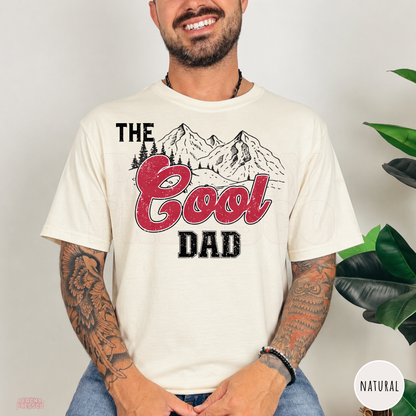 Natural t-shirt featuring The Cool Dad design with mountain scenery and distressed red lettering, a casual gift for dads.