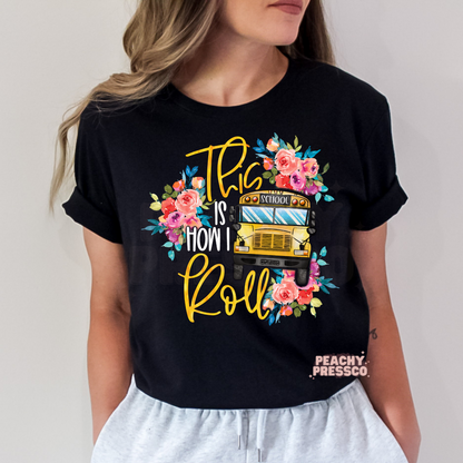 Black teacher t-shirt featuring a floral yellow school bus with "This Is How I Roll" typography and watercolor flowers.