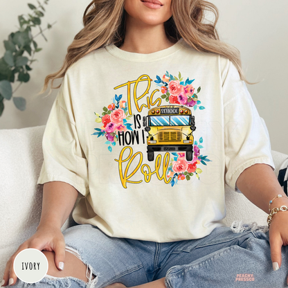 Ivory Comfort Colors teacher t-shirt with a floral yellow school bus and "This Is How I Roll" graphic, ideal for back-to-school.
