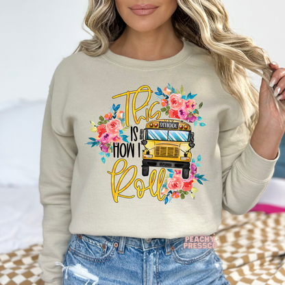 Sand teacher sweatshirt featuring a floral school bus graphic with the phrase "This Is How I Roll," perfect for teachers and back-to-school.