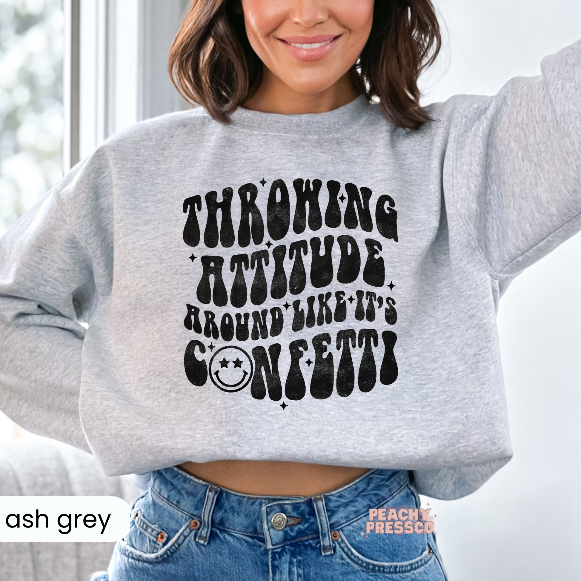 Ash grey sweatshirt featuring the humorous "Throwing Attitude Around Like It's Confetti" distressed retro graphic design.