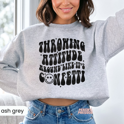 Ash grey sweatshirt featuring the humorous "Throwing Attitude Around Like It's Confetti" distressed retro graphic design.