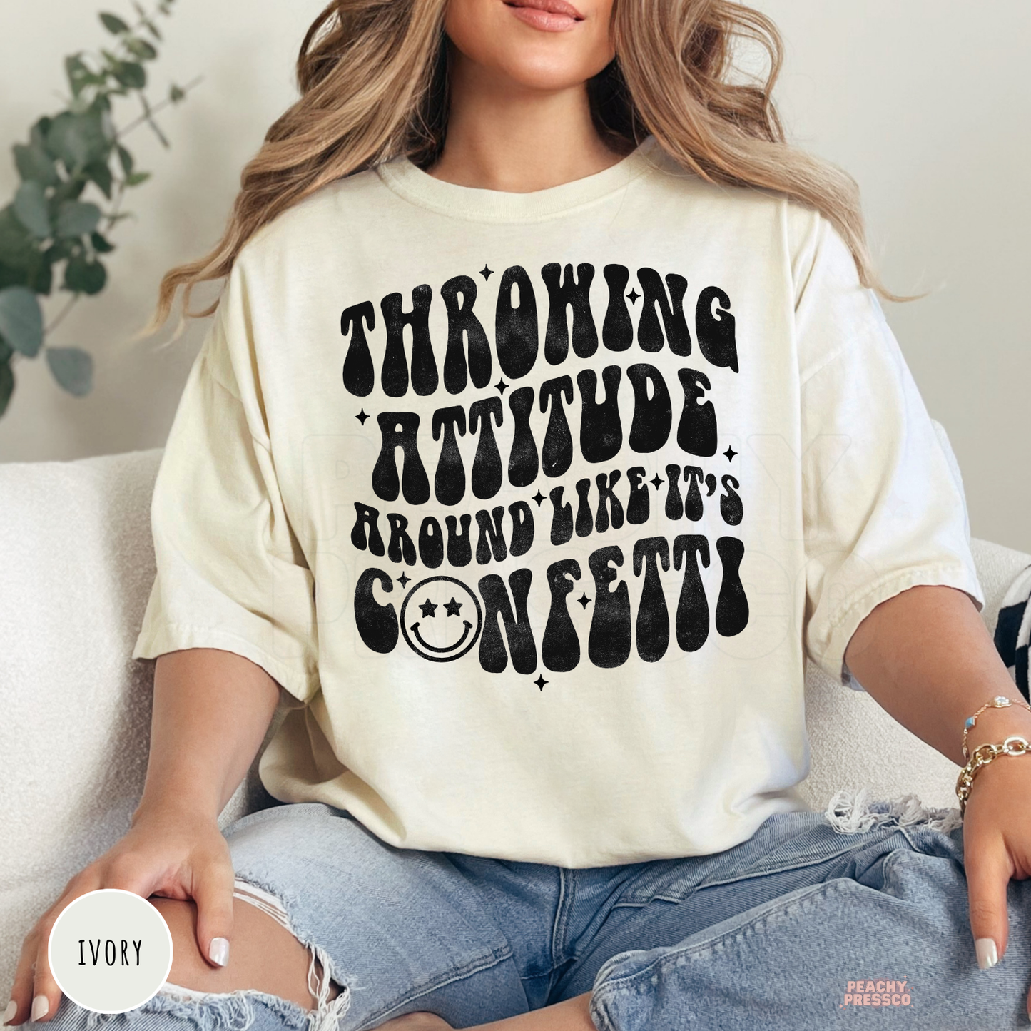 Ivory Comfort Colors graphic t-shirt with the phrase "Throwing Attitude Around Like It's Confetti" in a retro distressed font.