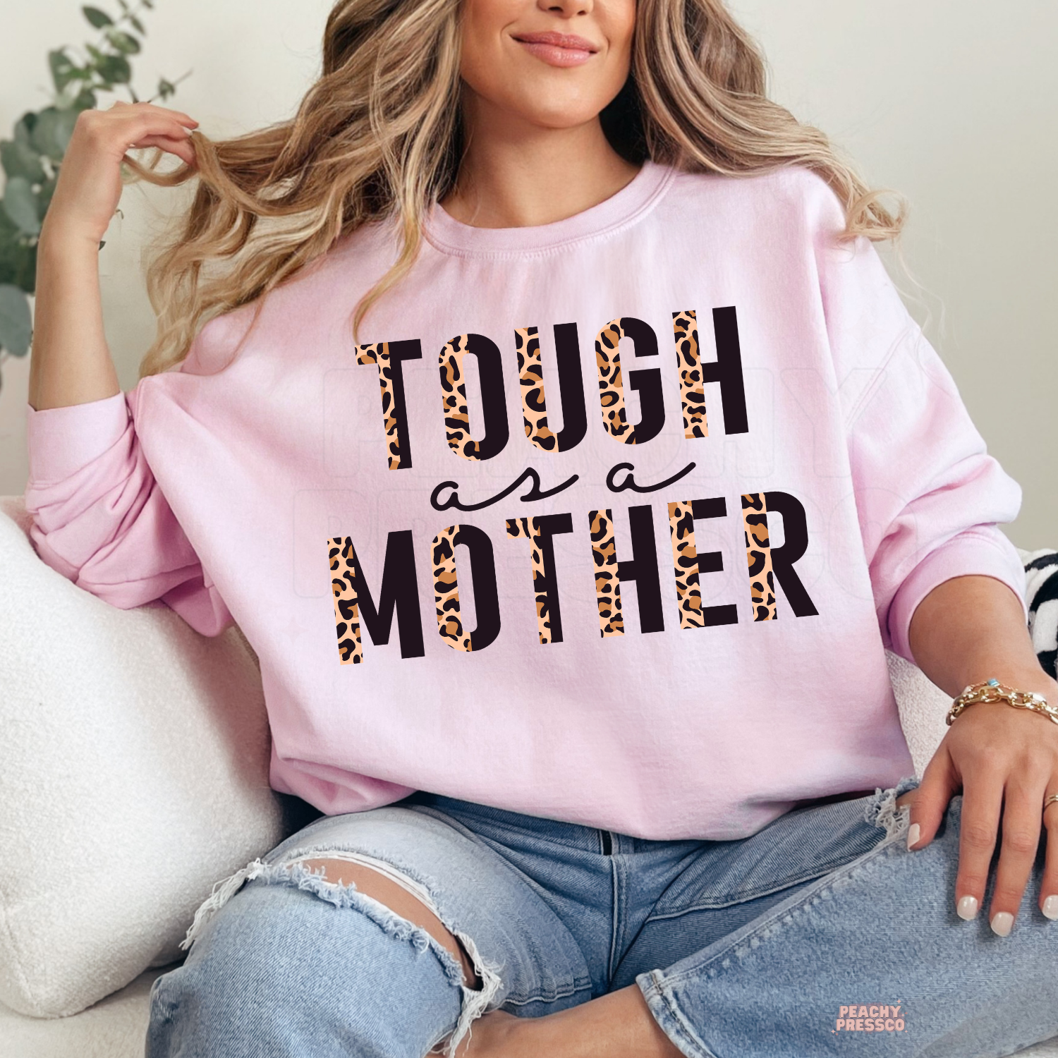 Light pink sweatshirt featuring a bold "Tough as a Mother" leopard print graphic. Funny and stylish Mother's Day sweatshirt for moms.