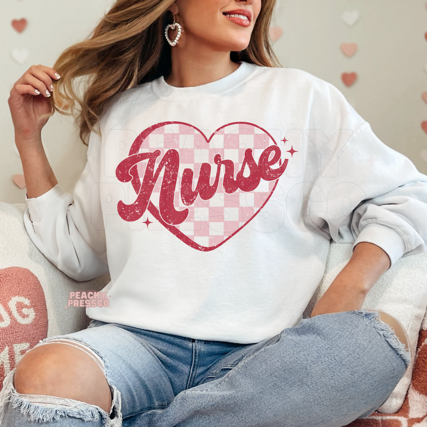 White crewneck sweatshirt showcasing a distressed Nurse script with a pink gingham heart for a trendy Valentine's nurse outfit.