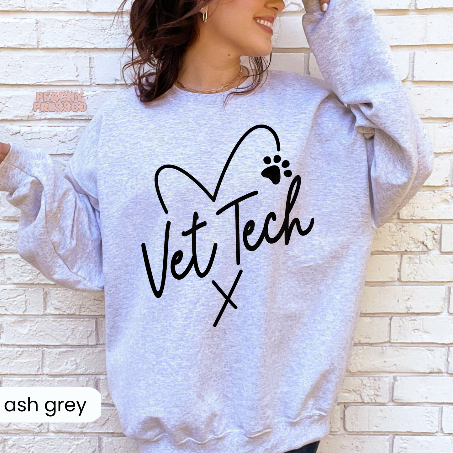 Ash grey sweatshirt with a black Vet Tech heart and paw print design, comfortable veterinary technician apparel and gift for animal care professionals.