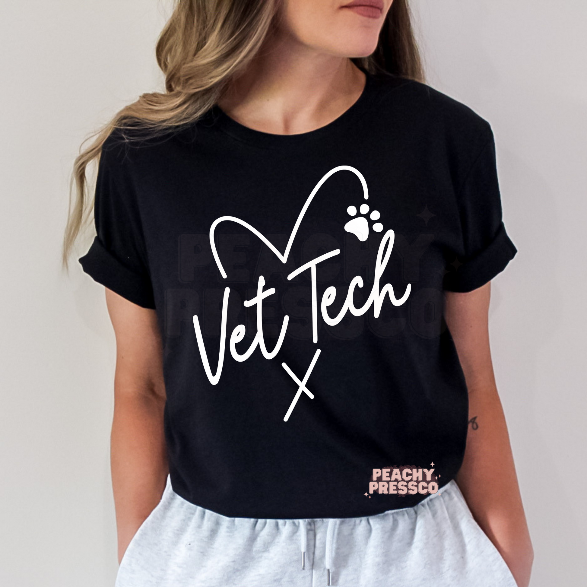 Black t-shirt with a white Vet Tech heart and paw print design, perfect veterinary technician shirt for work, school, or casual wear.