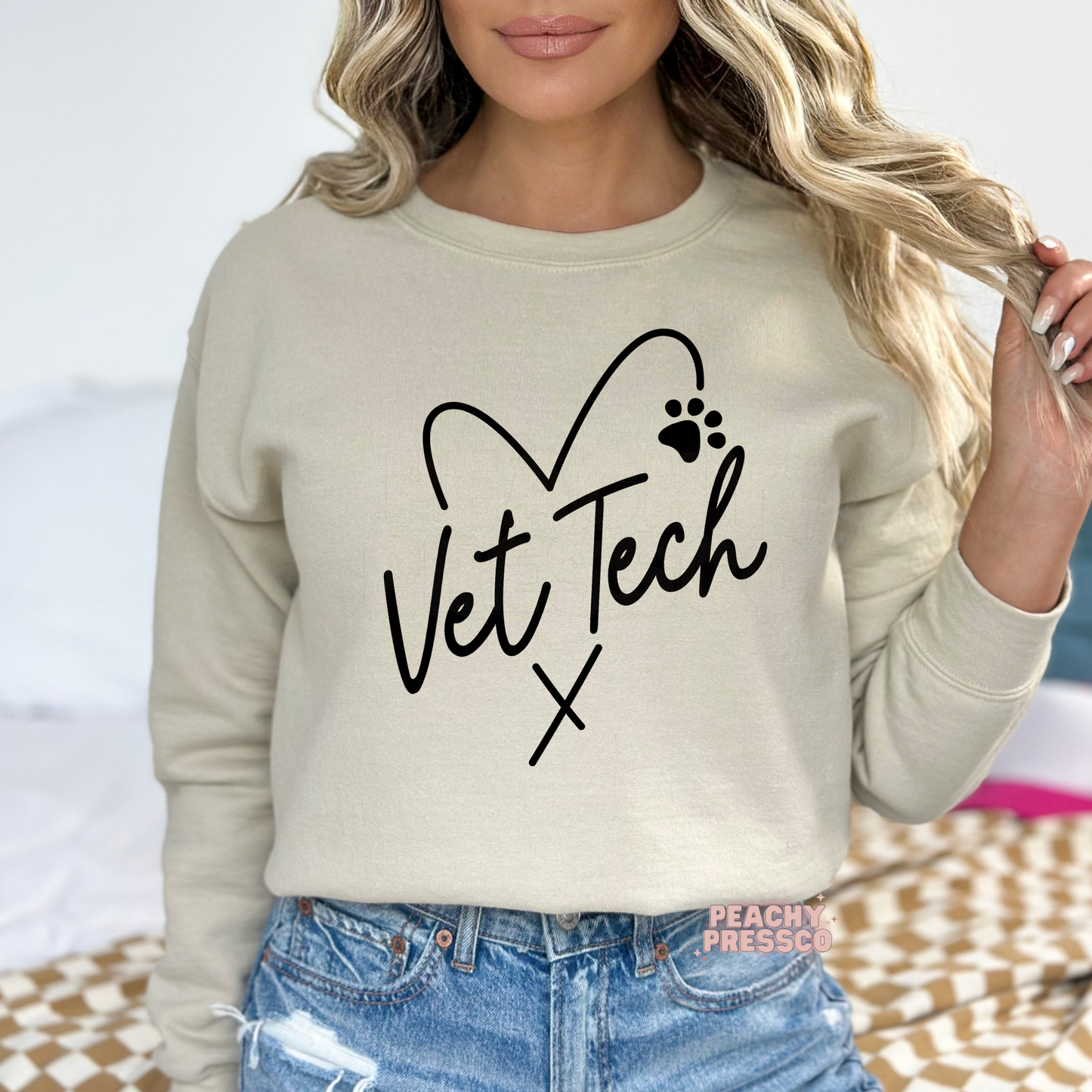 sand colored sweatshirt featuring a minimalist Vet Tech heart design with a paw print, perfect veterinary technician apparel for everyday wear.