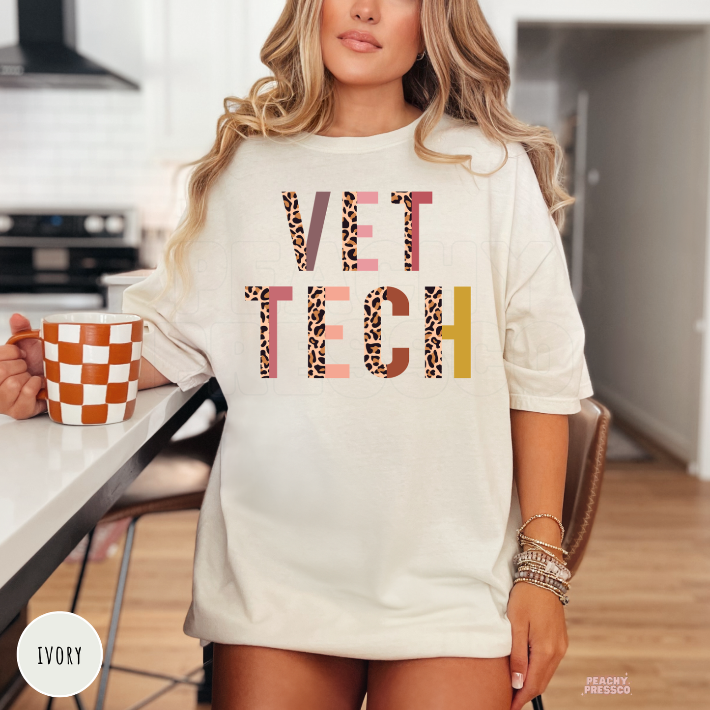 Woman wearing an oversized ivory t-shirt with a leopard print Vet Tech graphic, perfect everyday apparel for veterinary professionals.