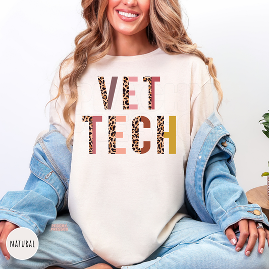 Woman wearing a natural-colored shirt with a bold leopard print Vet Tech design, a stylish gift for veterinary technicians and animal care professionals.