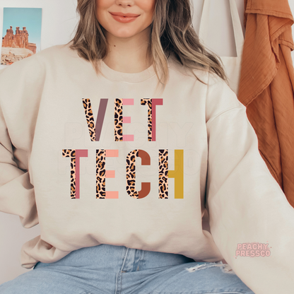 Sand crewneck sweatshirt featuring a colorful leopard print Vet Tech design, a cozy gift for veterinary technicians and veterinary assistants.