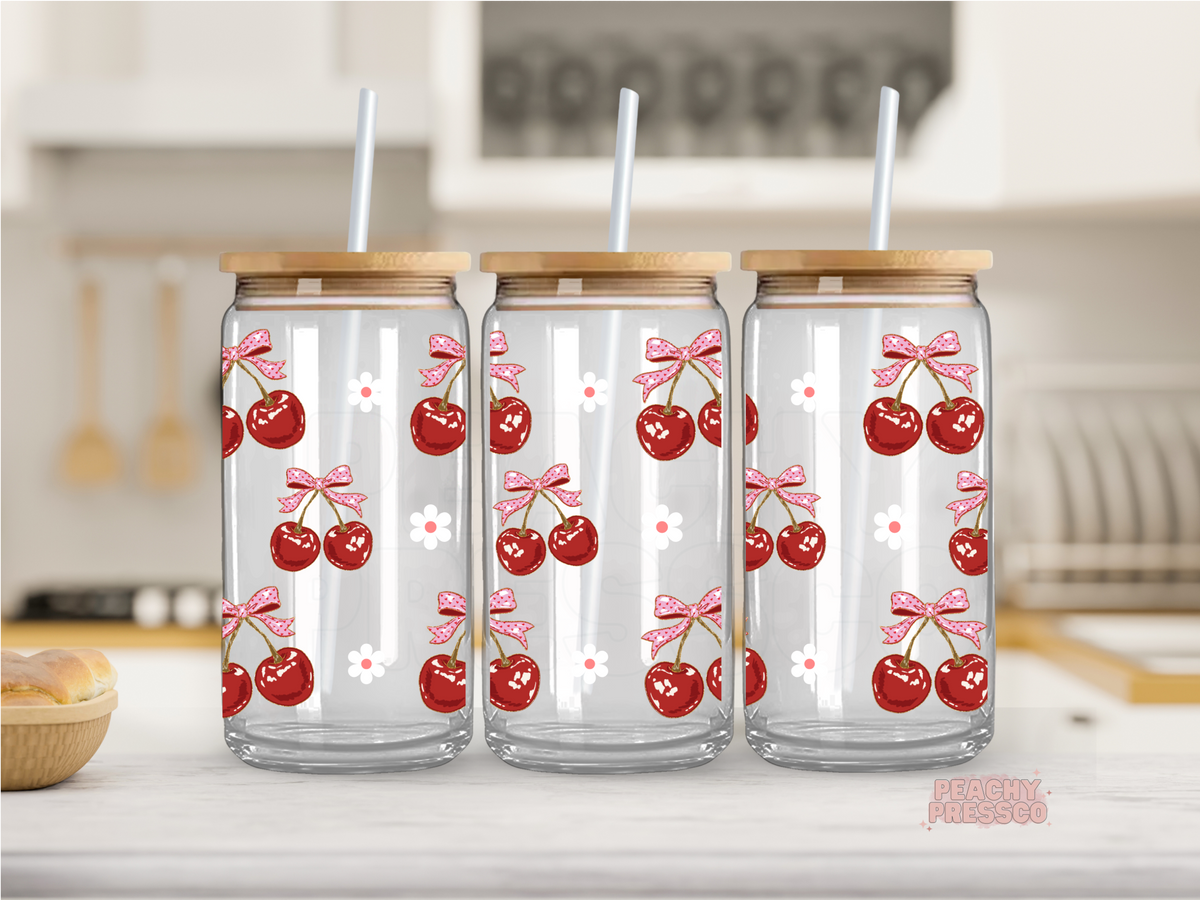16 oz glass cup featuring vintage-style cherries with pink bows and tiny white flowers, finished with a bamboo lid and glass straw.