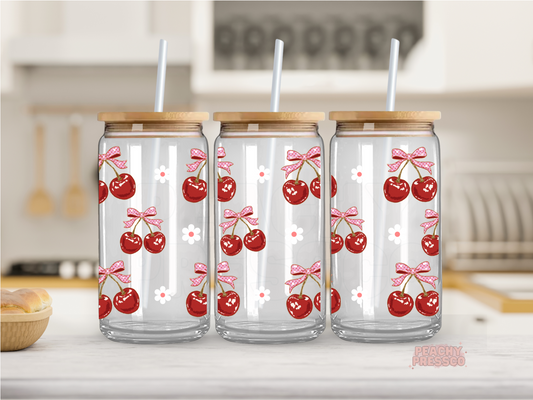 16 oz glass cup featuring vintage-style cherries with pink bows and tiny white flowers, finished with a bamboo lid and glass straw.