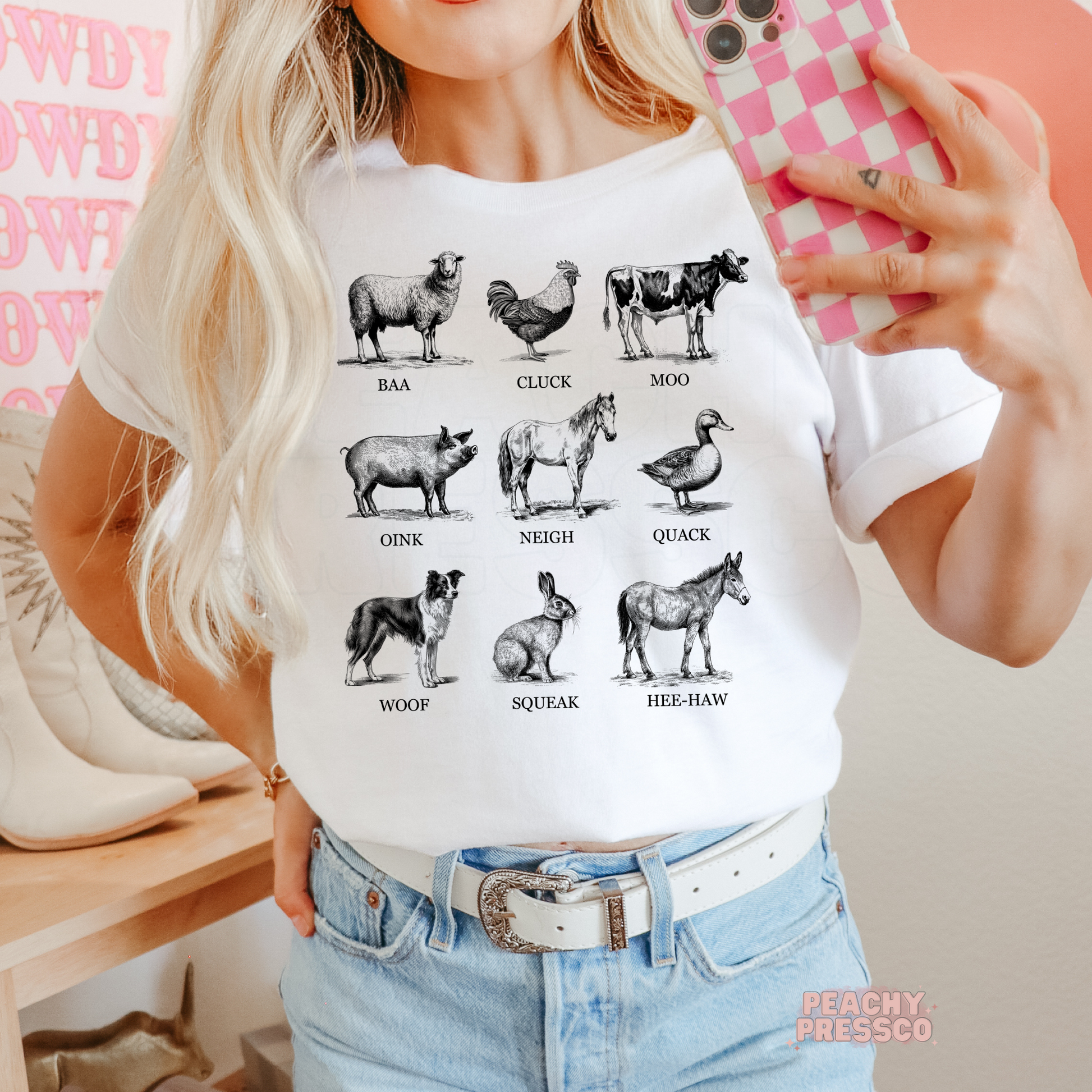 Woman wearing a white t-shirt with a vintage farm animal sounds graphic featuring classic black and white farm illustrations.